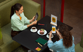 People using tablets and phones in cafe